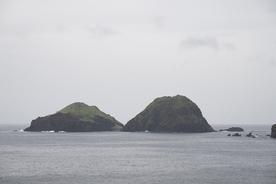 願集落からの光景。荒波に耐えて2匹の亀がじっとうずくまっているように見える島が二ツ亀。