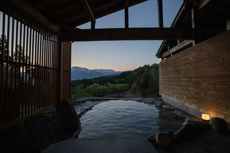 日本百名山の巻機山をはじめとした越後の名峰を一望できる露天風呂「湯処 天の川」。一面の雪が溶け、新緑に覆われた景色も圧巻。