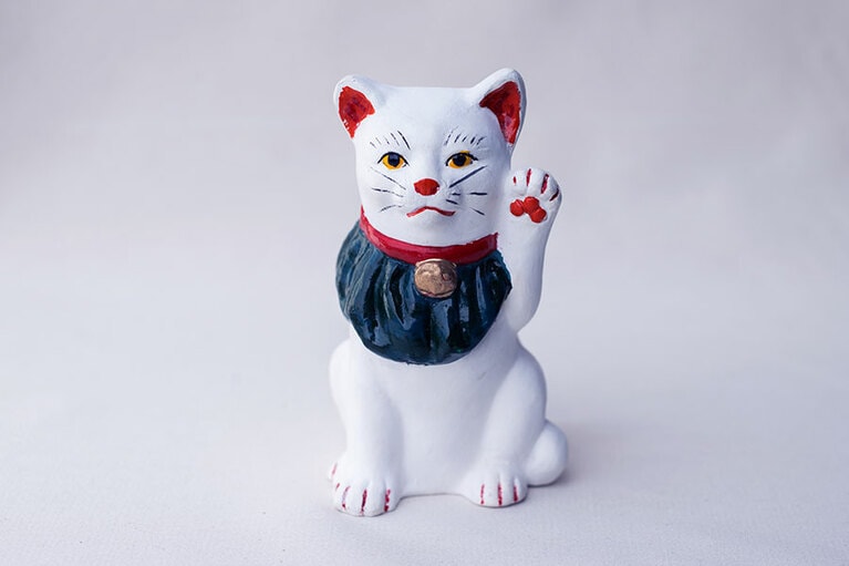 島根を代表する伝統芸能・石見神楽のお面作りを手がけている日下義明さんによる浜田市の工芸品・長浜人形。なんともいえない表情がたまらない“招き猫（小）” 2,750円。