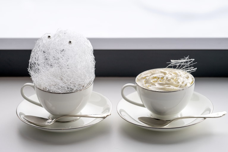 左から、霧氷をイメージした飴細工をのせた「霧氷コーヒー」900円、ふわふわのクリームの甘さで体がじんわり温まる「霧氷ミルクティー」700円。