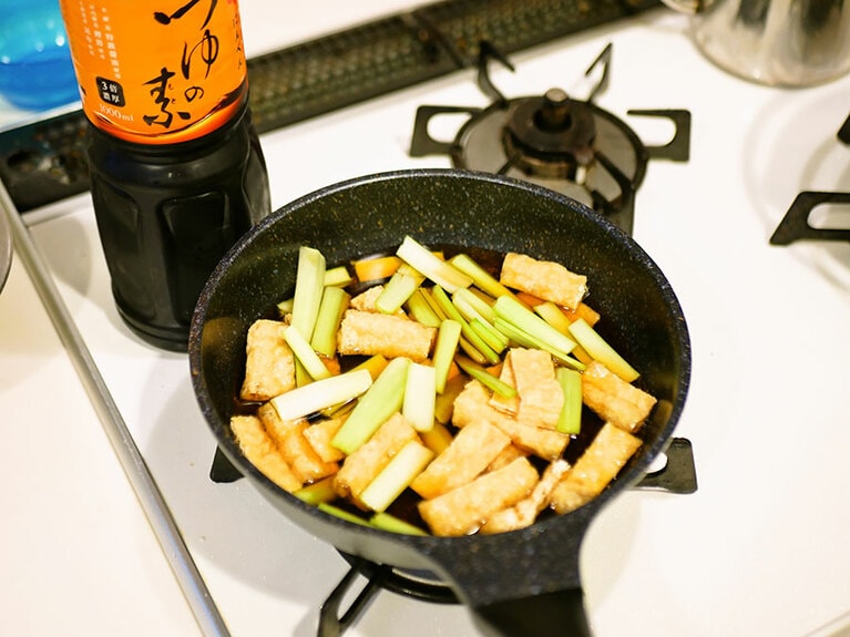 フライパンに茎と油揚げ、水、めんつゆを入れて中火にかける。