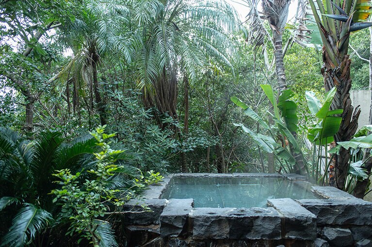 石造りの露天風呂は、まるで森の中のスパのよう。天気がいい日は、満天の星を仰ぎながらバスタイムを。