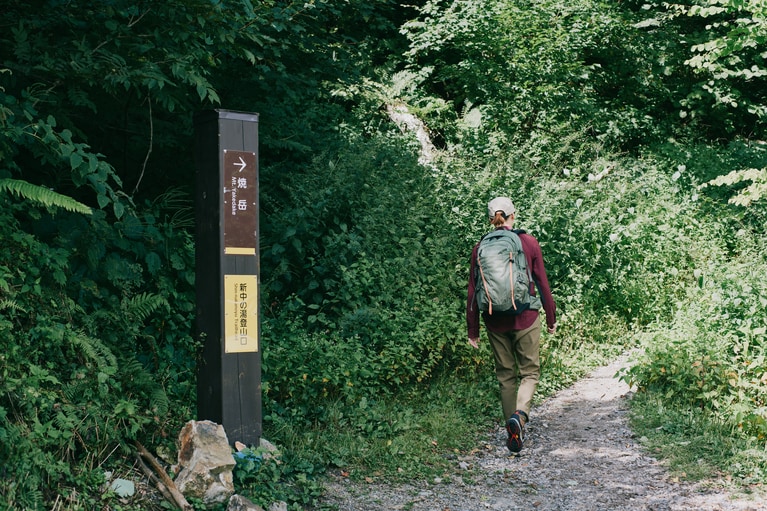 今回の登山のスタート地点は「新中の湯登山口」から。ハイシーズンは早朝から満車になるので、余裕を持って出発を。ハイキングシューズにはスティーンズピーク ツー アウトドライ 18,920円／コロンビアスポーツウェアジャパン
