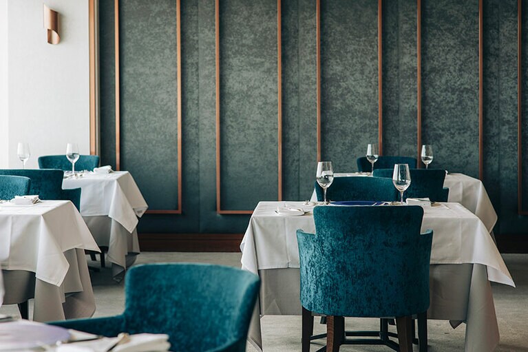 純白のクロスでシックな内観に濃いブルーのチェアがアクセント。