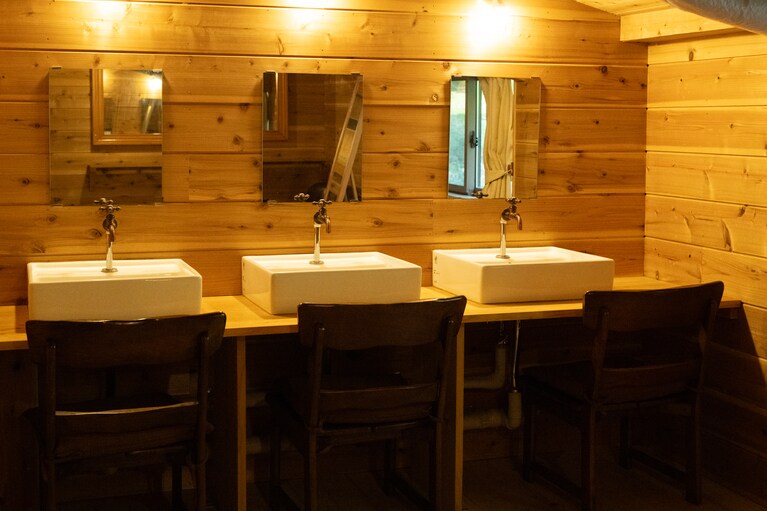 清潔感たっぷりの洗面台には椅子まで配置され、至れり尽くせりだ。