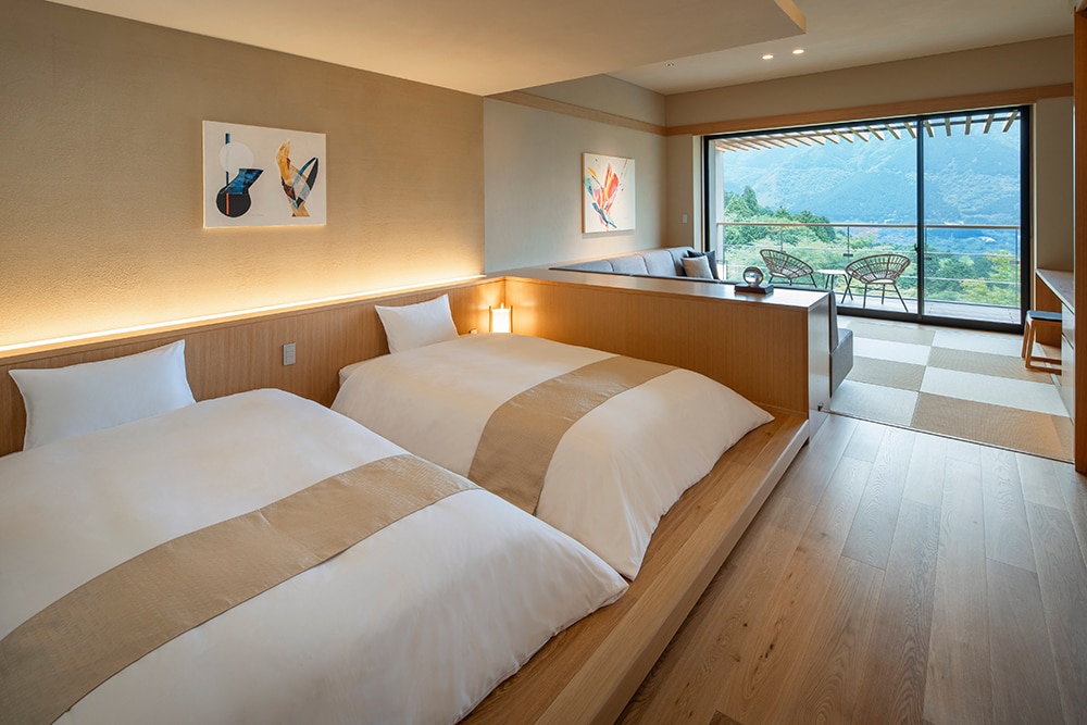 全室露天風呂付きの客室は、琉球畳の上にソファーを配した和洋室タイプ。客室の大きな窓、テラスにある露天風呂からも山々が連なる仙石原の雄大な風景を望むことができる。
