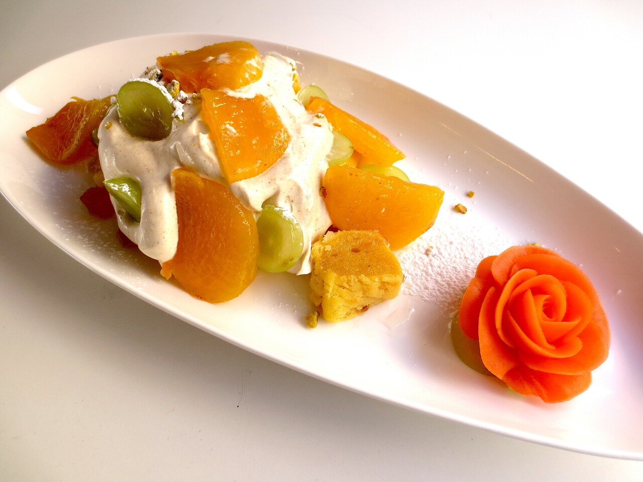 「ノランノラン餅ケーキ」1350円。トッピングは焼き柿。なつめクリームの下にはカステラ インジョルミが。あんフラワーを飾った魅力的な一皿。