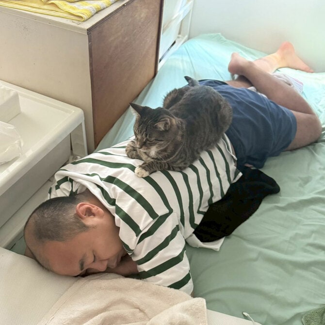 高野さんの上でくつろぐごま吉。