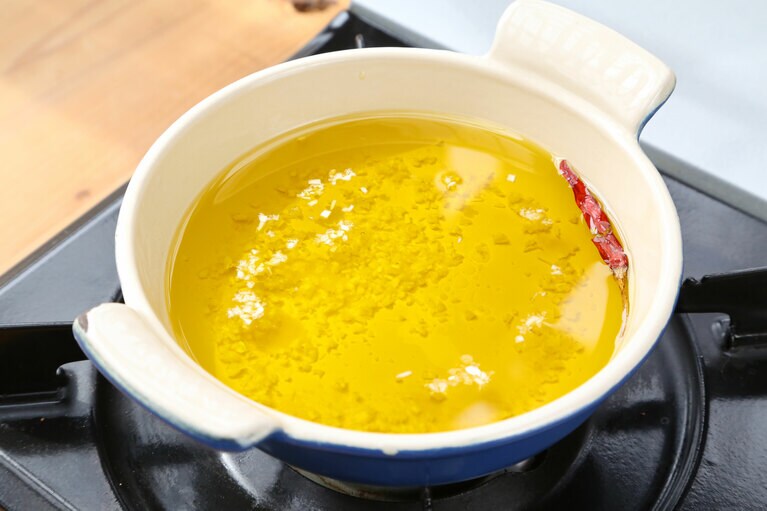 オリーブオイルににんにくと唐辛子、塩を入れて弱火にかける。