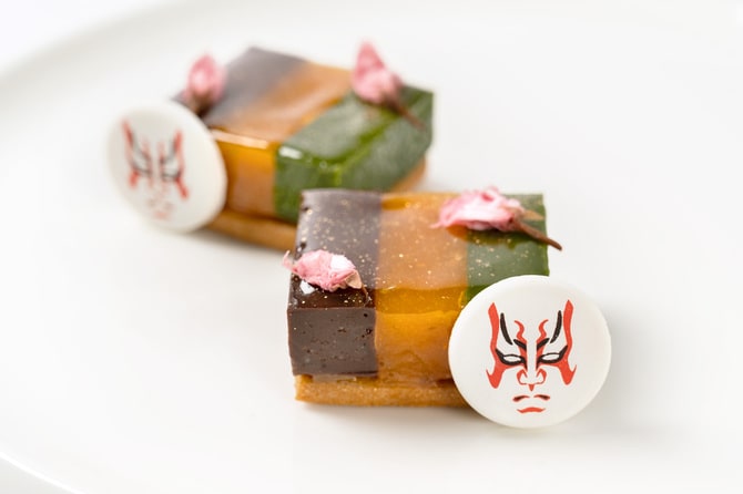 チョコレートと抹茶のテリーヌでアプリコットのハードゼリーを挟み、“隈取(くまどり)”のホワイトチョコレートを添えた「チョコレートテリーヌ アプリコットのパートドフリュイ 抹茶テリーヌ」。©SHOCHIKU