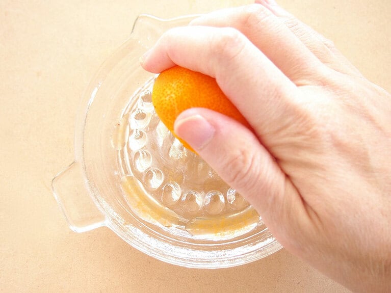 (1) みかんを横半分に切り、レモン絞り器などを使って絞ります。 