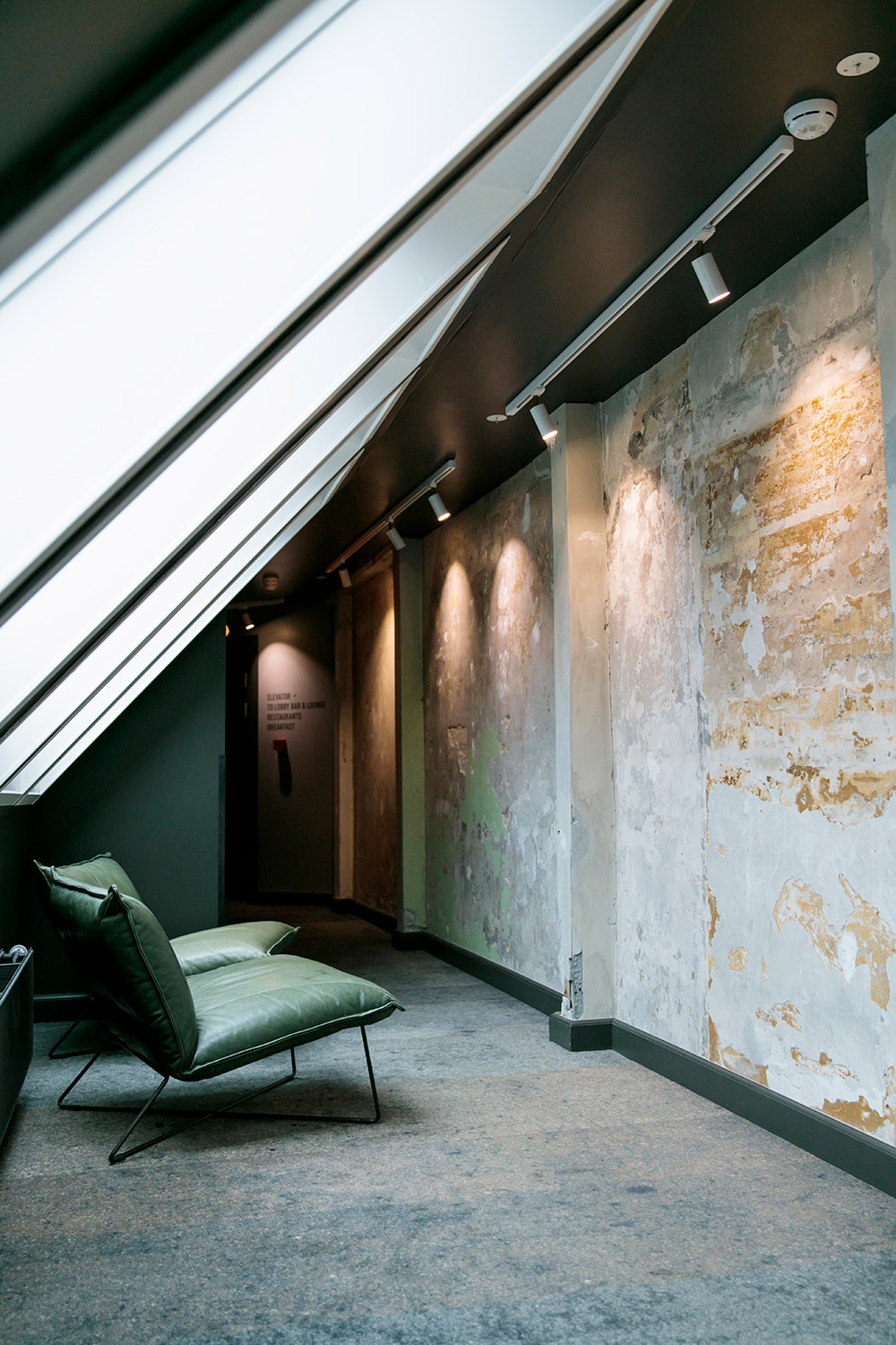 ホテル改装時の古い壁を生かし、外を歩いているようなデザインにした廊下。絨毯はアスファルトを摸している！