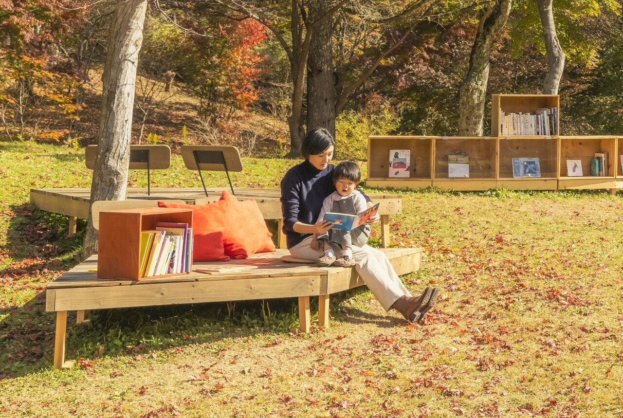 木漏れ日の中、親子で読書を楽しむひととき。