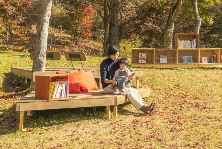 木漏れ日の中、親子で読書を楽しむひととき。