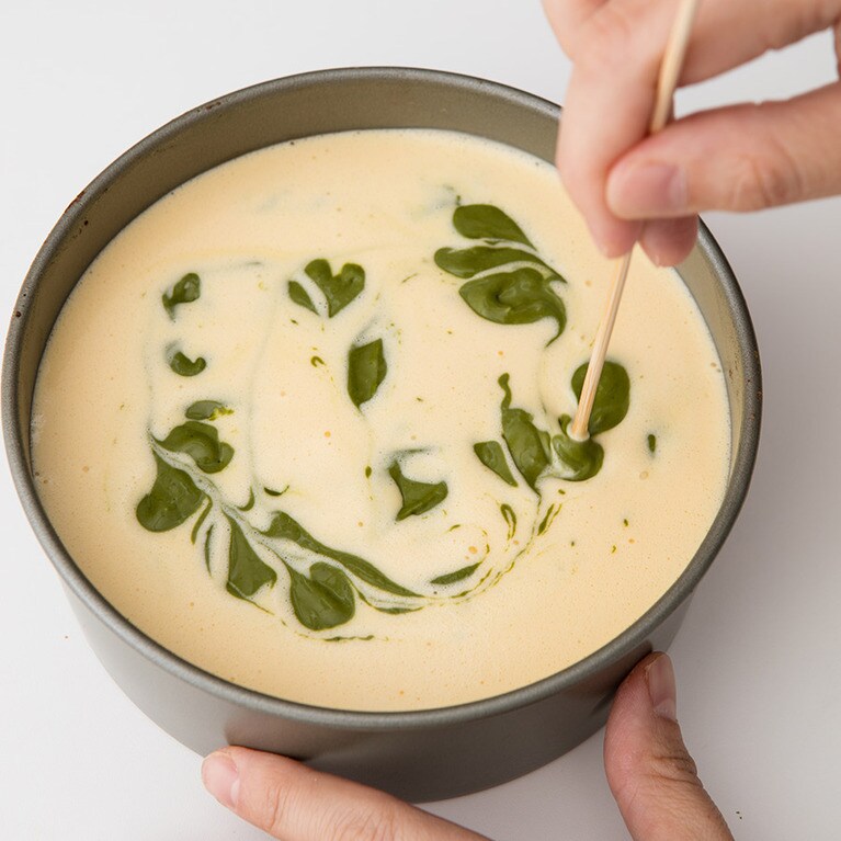 抹茶のチーズ生地を6～8カ所ほど落とし、竹串でマーブル模様にする。