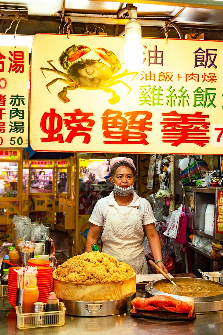 「基隆廟口夜市」で名物の、蟹身入りとろみスープと中華風おこわの店。湯気の立った炊き上がりが大ザルに次々と補充され、食欲をそそる。