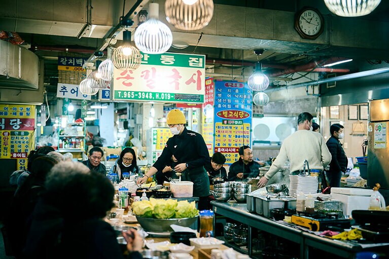 新館地下1階にある店内では安東の方言で手打ち麵を意味するソングッシが絶え間なく茹でられる。毎日仕込まれる小麦粉60％に大豆の粉40％を配合した麵と、大豆の甘味が染み出したスープにニンニクとヤンニョンを入れて食す。／安東チッ（アンドッチッ／안동집）