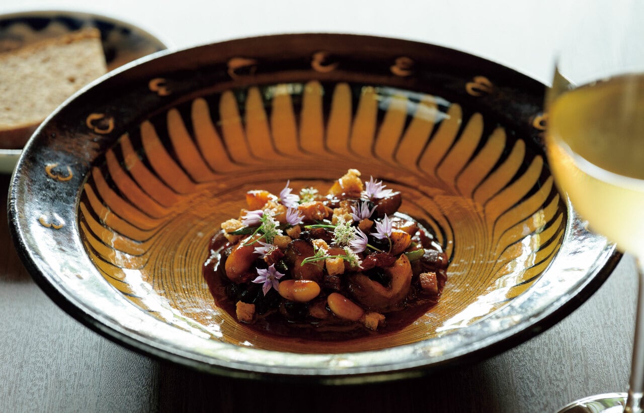 布志名焼の器に盛られた「サザエと白インゲンのフリカッセ」。