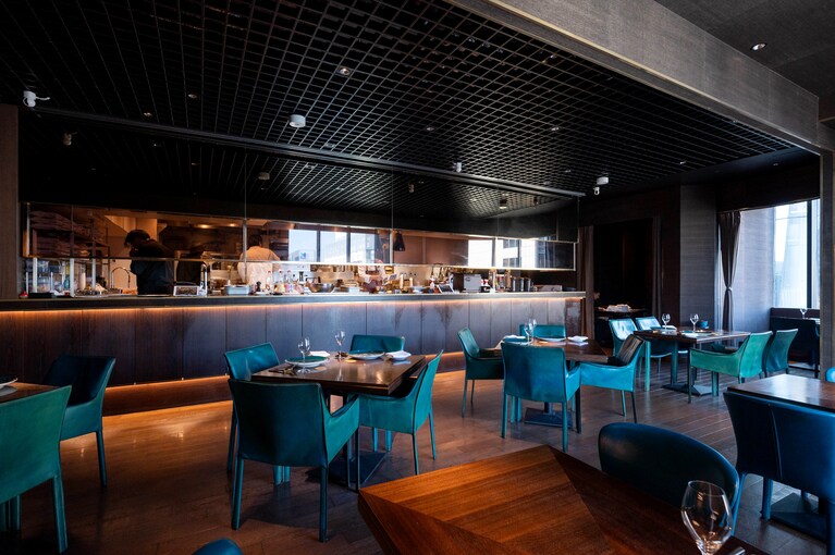 インドの国鳥であるクジャクの羽の中の一色、ピーコックブルーで統一されたショープレートと椅子が華やかで美しい店内。