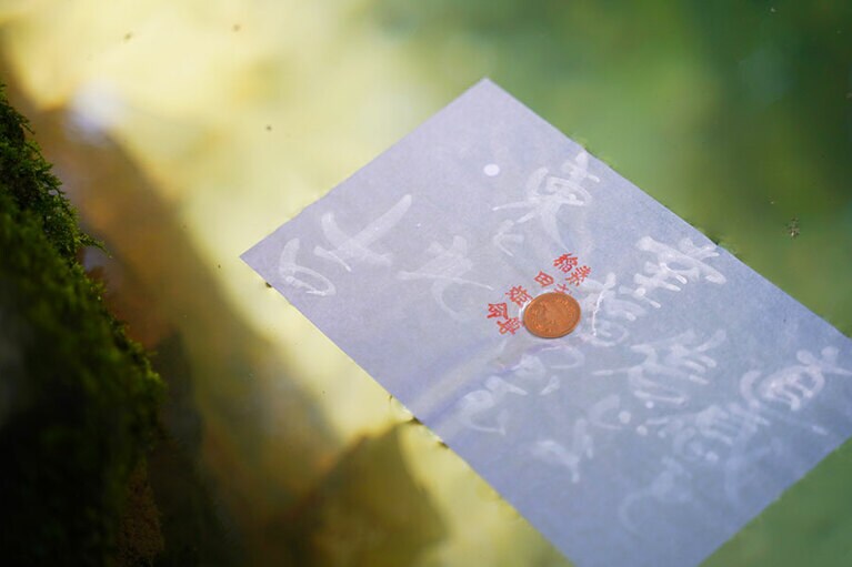 硬貨の沈み方で縁を占う。占い用紙は神札授与所にて100円で販売。