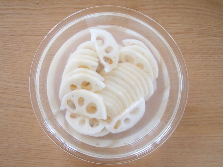 蓮根は皮をむき、半割りにして薄切りに。ボウルに水を張り、蓮根を入れて10分ほどあく抜きをする。