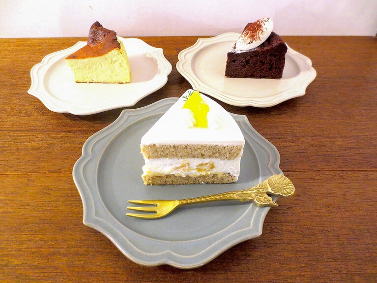 左奥が、生菓子の定番「チーズケーキ」680円、右奥が「米粉のガトーショコラ」700円、手前の「ショートケーキ」は取材時の「春かんきつとアールグレイのショートケーキ」730円。他に「自家製プリン」650円、「苺とクリームチーズのベイクタルト」680円、「ヴィクトリアケーキ」750円、「自家製あんバター　スコーンサンド」600円なども。