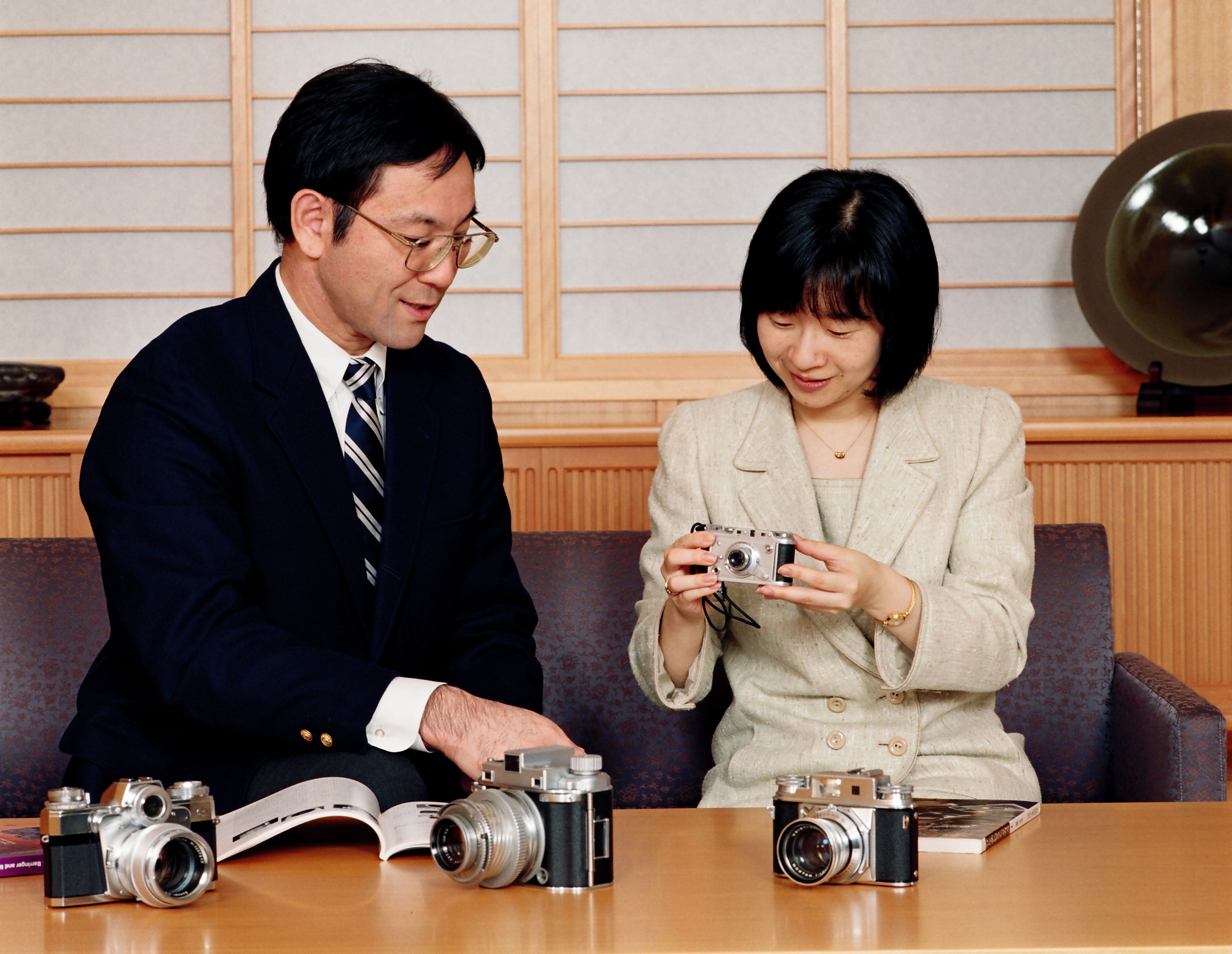 黒田慶樹さんが趣味で集めた珍しいクラシックカメラを手に取る紀宮さま（当時）　宮内庁提供