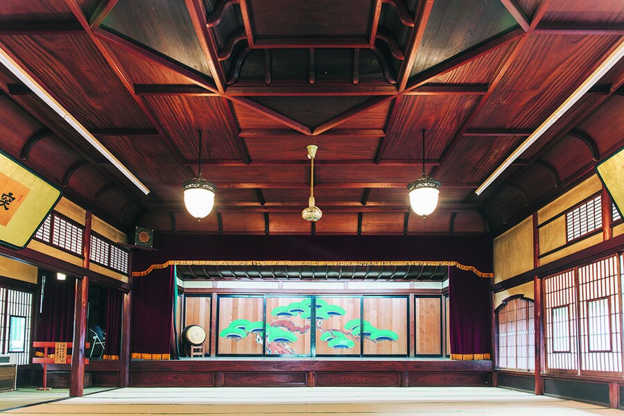 【元湯 環翠楼】代杉と欅を使用した舞台付き大広間「万象閣」は本館4階にありいつでも見学可。2種の木材を用いた二重折上格天井や、鏡板のような松を描いた舞台の杉戸が特徴的。Photo: Masahiro Shimazaki