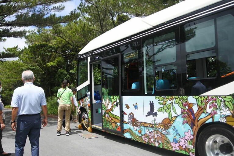やんばるの森の昼と夜を描いたボディの電気バス。乗車前には余計なものを持ち込まないように、靴裏の泥を落とします。