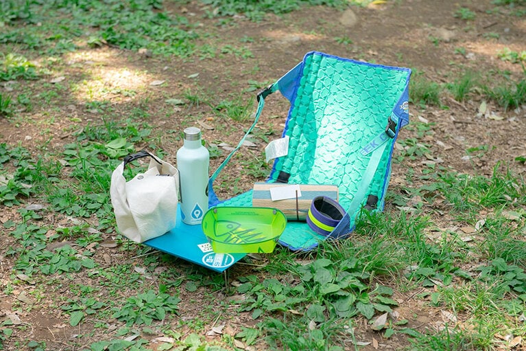 スノーピークのサヨウ（茶踊）、コークシクルの水筒、SOTOのミニテーブル、Fozzilsのフォールディングボウル、クレイジークリークのチェア、ブルーボトルコーヒーのレジャーマット、ブルーラグのアンクルバンド。これがあればいつでも自転車ピクニックに！