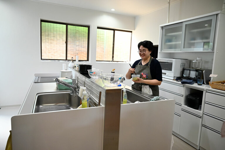 キッチンで料理する、腸美活ライフスタイルマスターの菊地あゆみさん。