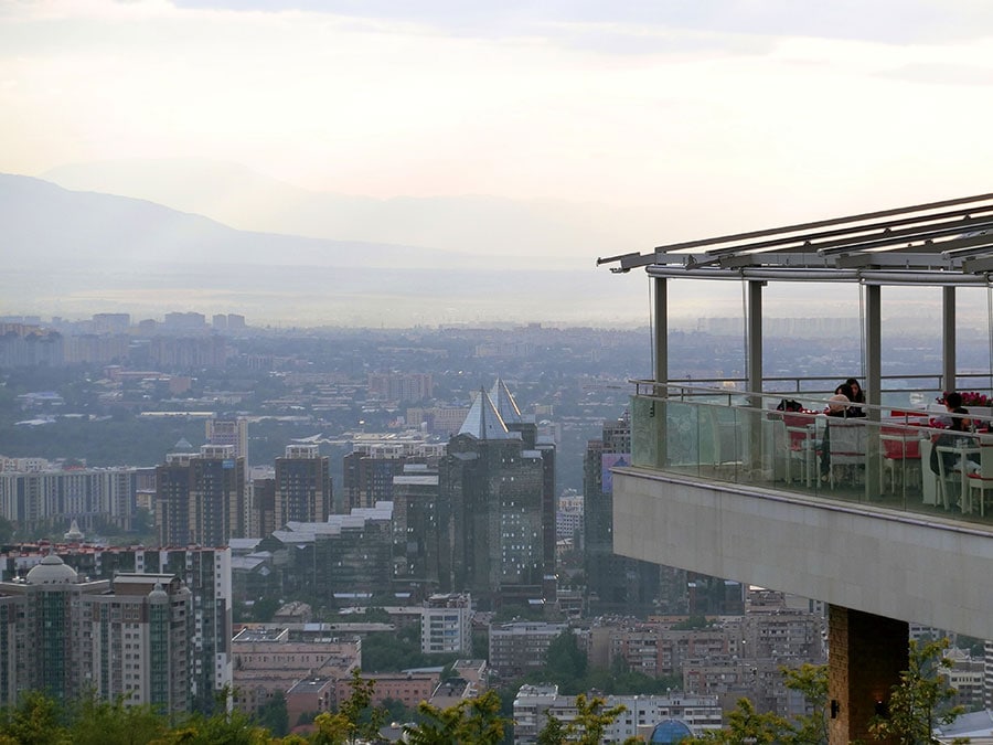 アルマトイの絶景スポット、「コクトベ」から市内を一望。天山山脈を背景に高層ビルが立ち並ぶ。