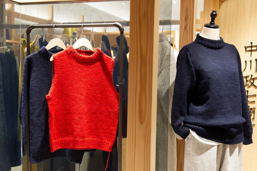 麻わたウールのセーター 紺 22,000円(写真右)、麻わたウールのベスト 赤 18,000円(写真中央)。