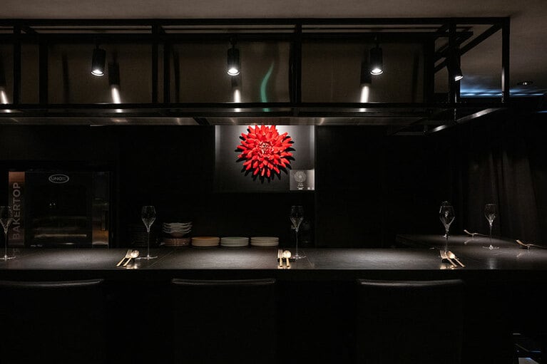 デザートやパフェが映える、黒で統一された店内。真っ赤なダリアのオブジェは、李荘窯の寺内信ニさんによる有田焼。