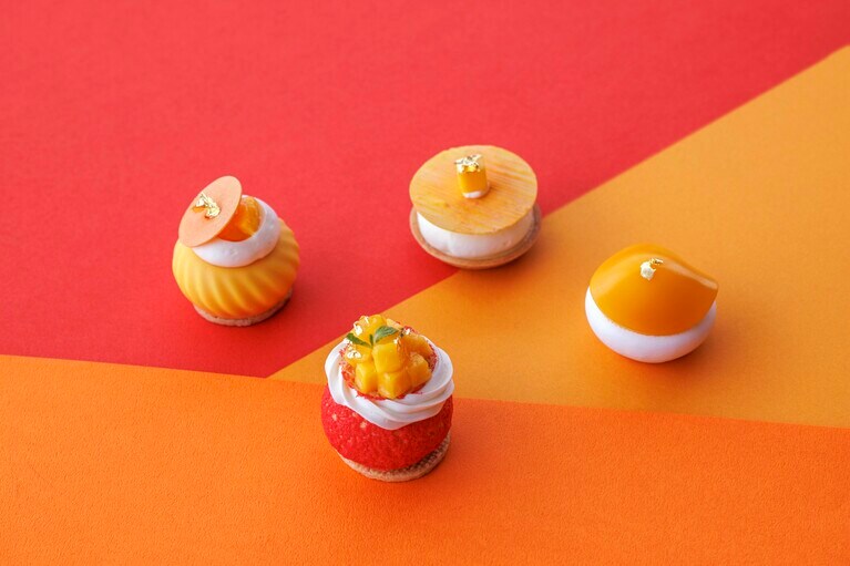 ジヴァラ・ミルクチョコレートクリームと、マンゴーコンポート、生マンゴーを詰めた贅沢な「マンゴー シュー」（写真手前）ほか、マンゴースイーツコレクションのイメージ。