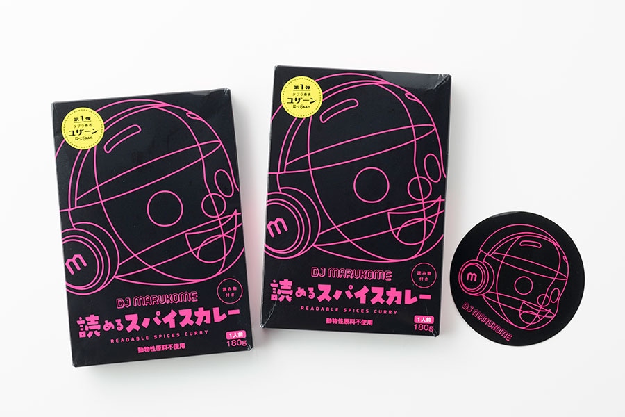 「DJ MARUKOME」×北野エース コラボレーションカレー 各430円(税込)。ステッカー付(数量限定)。
