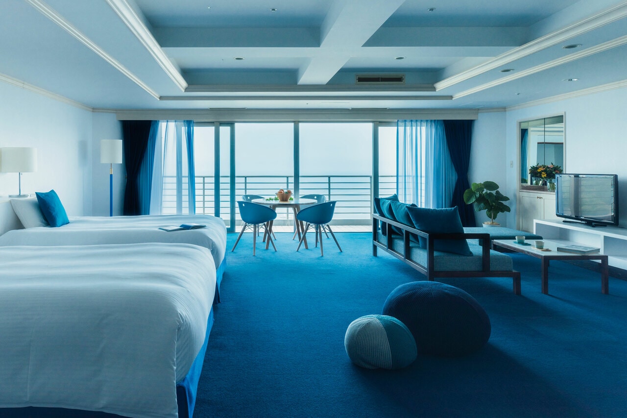 白壁にブルーが映える客室。どの部屋からも、相模湾と熱海の街を眺めることができる。