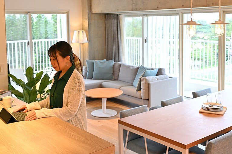 月に3回ほど出張や旅行に行くという佐藤さん。明るい光に包まれる「デラックススイート」でさっそくワーケーション。客室はすべて心地よいバルコニー付きで、リモートワークの合間にほっと一息……。