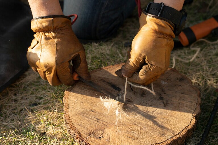 麻紐をナイフでおさえて、そのまま麻紐を引き抜く。