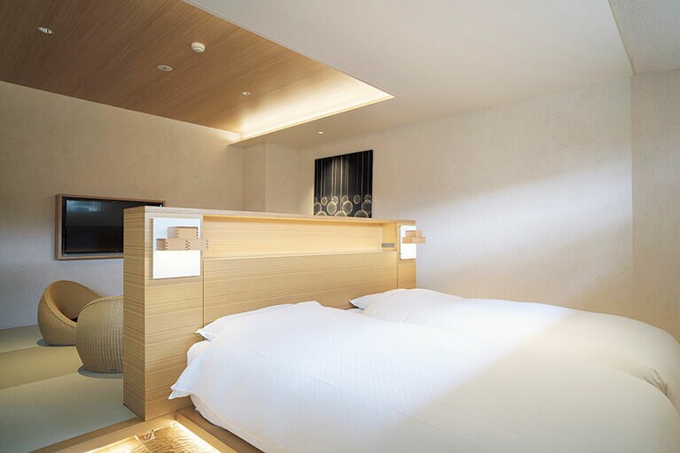 客室・椿は日本酒の升を重ねた特注照明など「アートとお酒」がテーマ。名栗仕上げの床が足に心地いい。