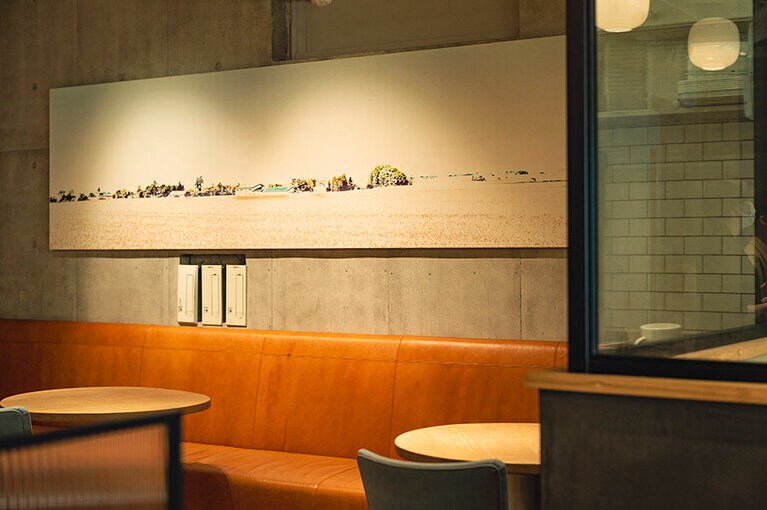 カフェの壁には北海道・砂川の景色が飾られている。