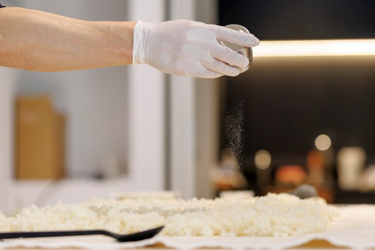 適温まで冷ました蒸したお米に、種麹をふりかけてよく混ぜていくだけ。ここからは温めて発酵させることで、菌糸とよばれる白い糸のようなものが生えてきて、麹になっていくのです。