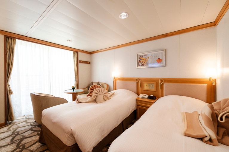 シックなインテリアでまとめられた室内には、愛らしく畳まれた花毛布が。ベランダを備えた開放感ある空間に二人も大満足。