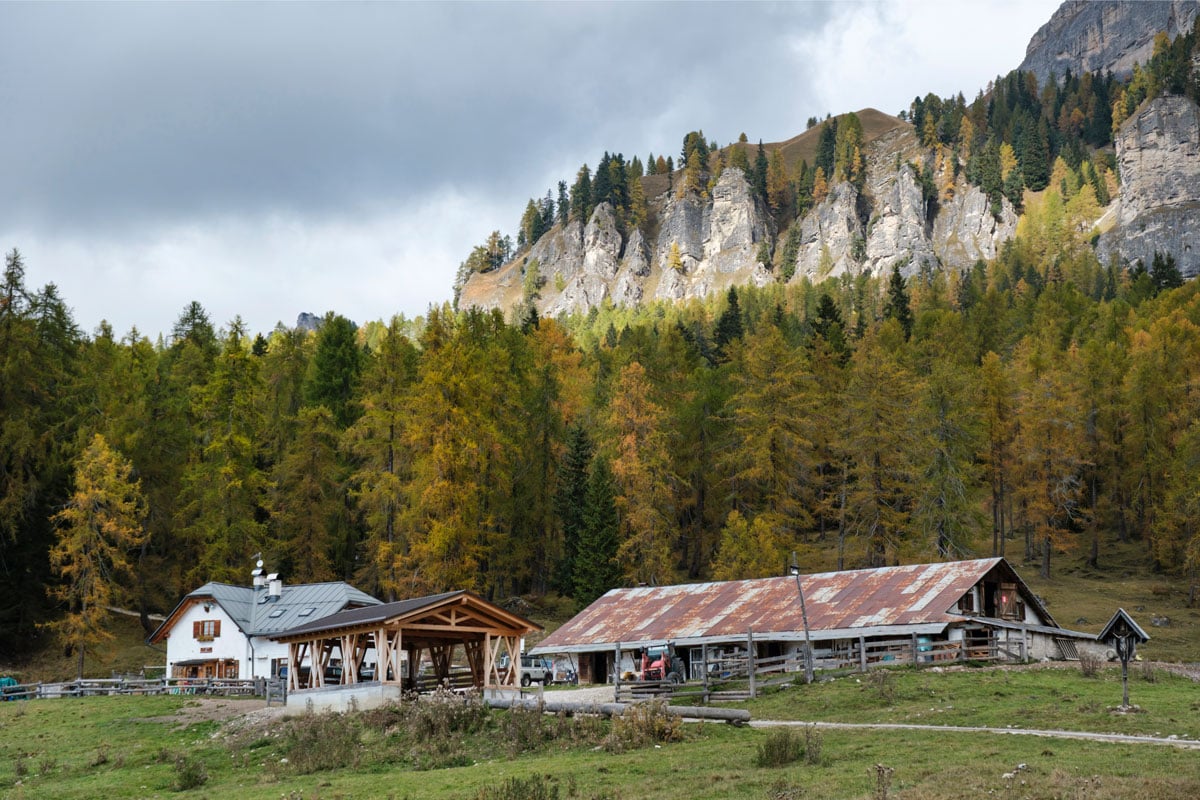 壮大な山を背景にしたアグリツーリズム「エル・ブリテ・デ・ラリエート」。白い建物がレストラン。大きな畜舎がある。