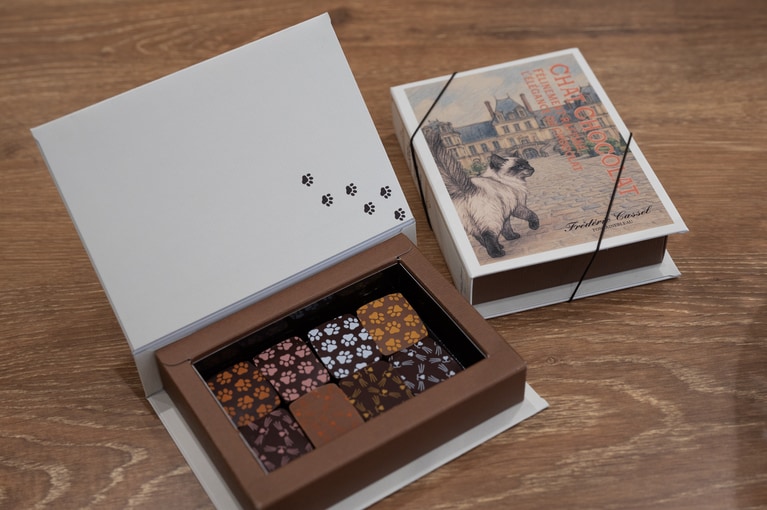 8つのボンボンショコラは左上から時計回りで、マルシェ（オレンジとシナモンのガナッシュショコラ）、シャルドン農園（フランボワーズのガナッシュショコラ）、ショコラトリー（トンカとヴァヌアツ産カカオのガナッシュショコラ）、ブティック（洋梨とキャラメルのガナッシュショコラ）、フォンテーヌブロー宮殿（カシス・ヴィオレのガナッシュショコラ）、カッセル家の庭（ジャスミンティーのガナッシュショコラ）、メゾン（レモンとエルダーフラワーのガナッシュショコラ）、アトリエ（桜香る煎茶のガナッシュショコラ、ローズのヒント）。