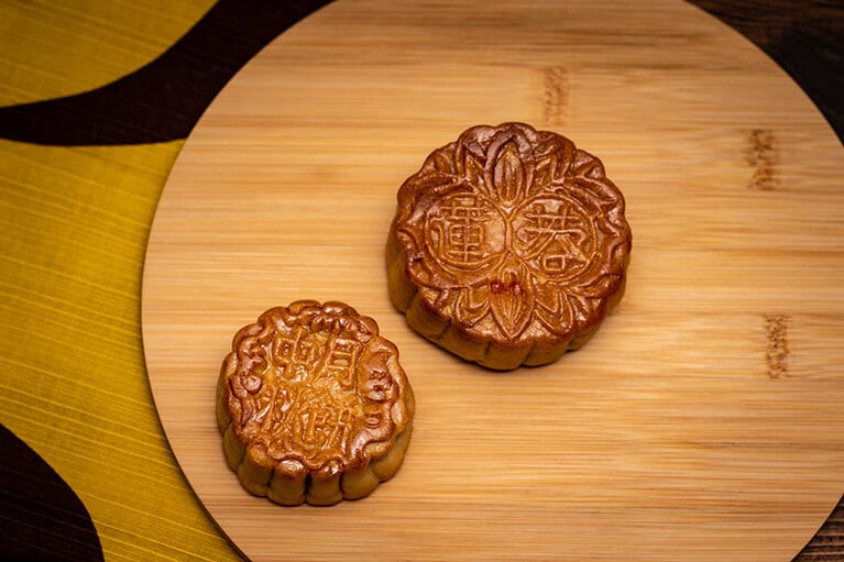 右上：「双黄蓮蓉（シュウアンファン リンヨン）大月餅」1,200円、左下：「蛋黄蓮蓉（タンファン リンヨン）中月餅」620円。2023年9月29日（金）までの限定。