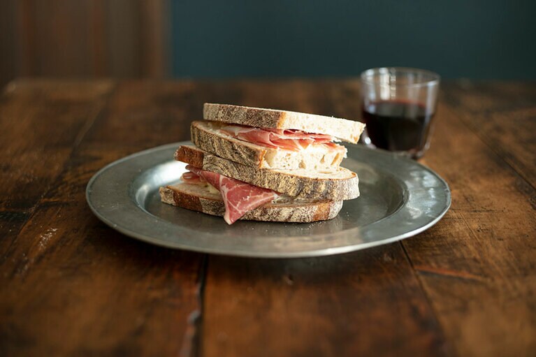 神戸から届く田舎パンに熊本発ジャージー牛のチーズ、添加物ナシの生ハムをたっぷり挟んで。
