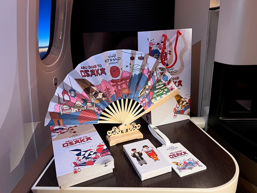 初就航便限定のギフト。OSAKAのロゴとイラストが入った扇子とラゲージタグ。扇子には台座が付いていて、立てて飾ることができる。