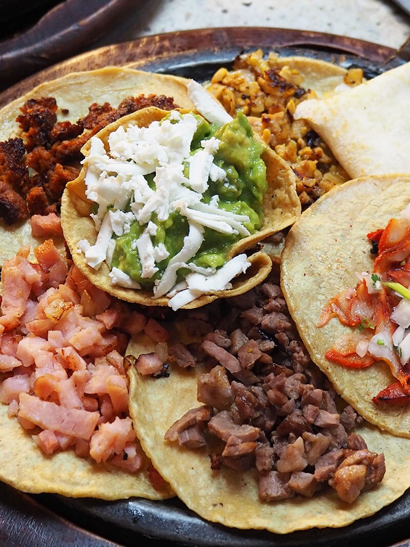 メキシコ・シティ「エル フォゴンシート」のタコス6種盛。ワカモレとチーズ、牛肉、豚肉、鶏肉、パストール(スパイスに漬け込んだ豚肉のグリル)など。「エル フォゴンシート」にて。