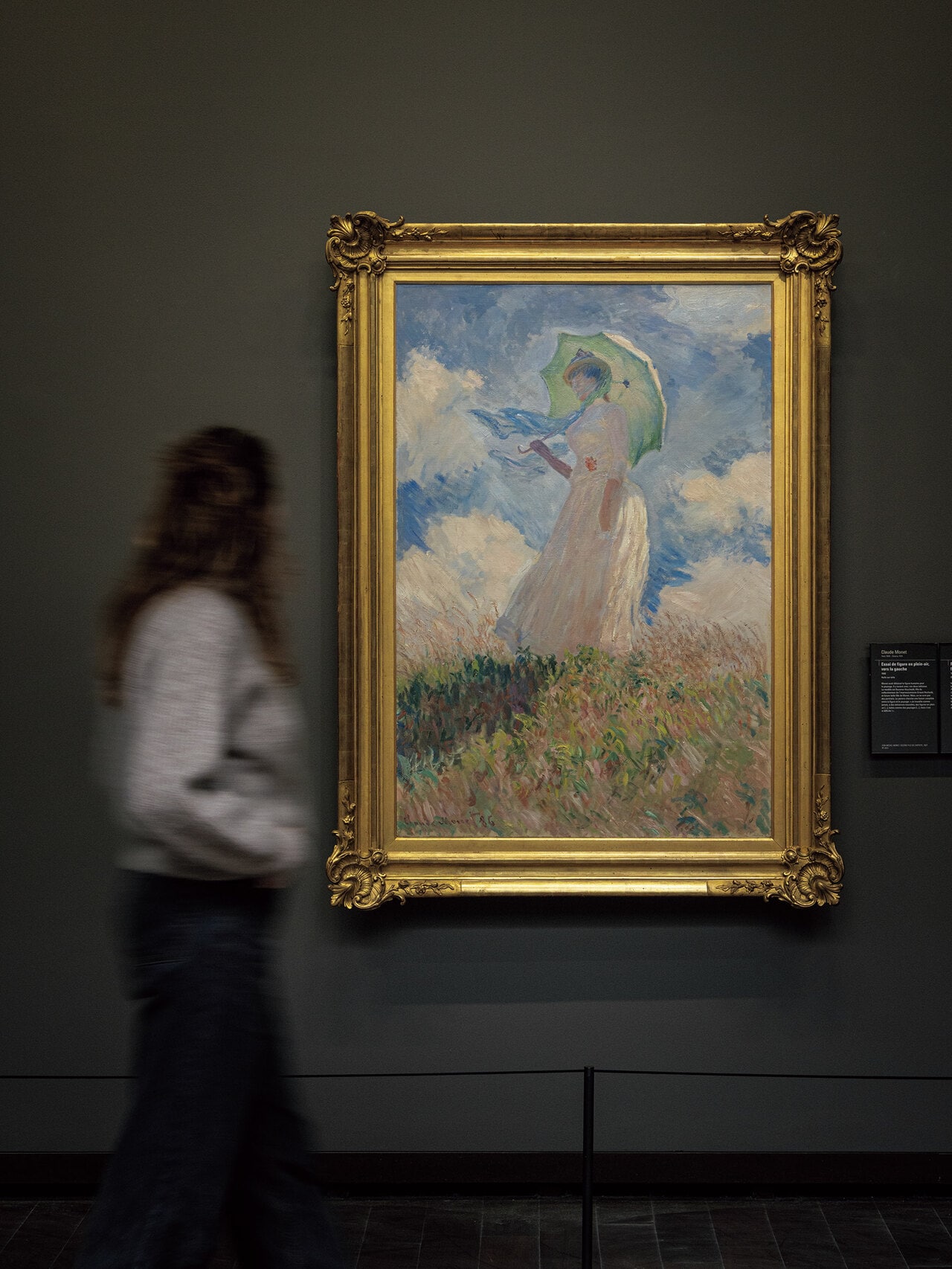 《戸外の人物習作：左を向いた日傘の女》（1886年）。モデルは再婚相手アリスの娘シュザンヌ。モネの死後、息子ミシェルが1927年にルーヴルへ寄贈、ジュ・ド・ポームを経てオルセーへ。